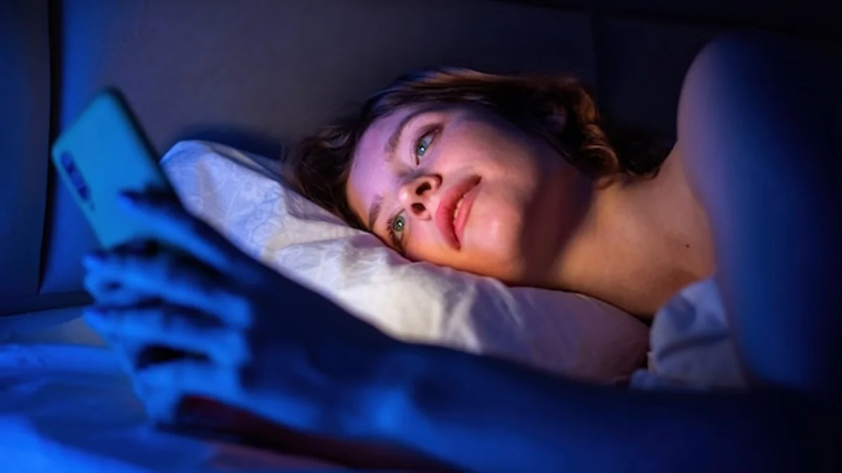 blue light from smartphone at night, sleepless woman