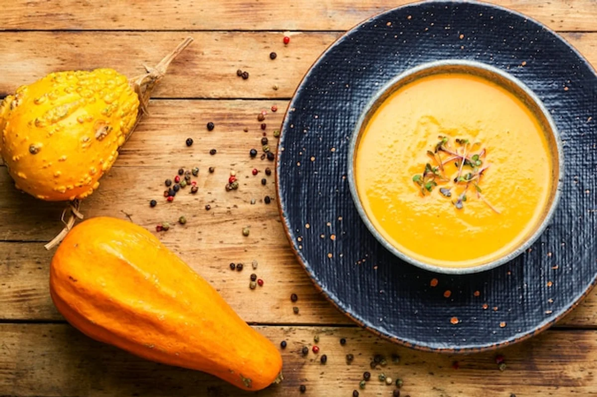 autumn pumpkin soup in rustic bowl on wooden table
