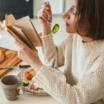 woman eating healthy food in cozy sweater winter mood