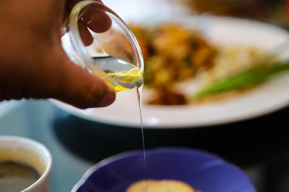 Italian chef pouring extra virgin olive oil over fresh bruschetta