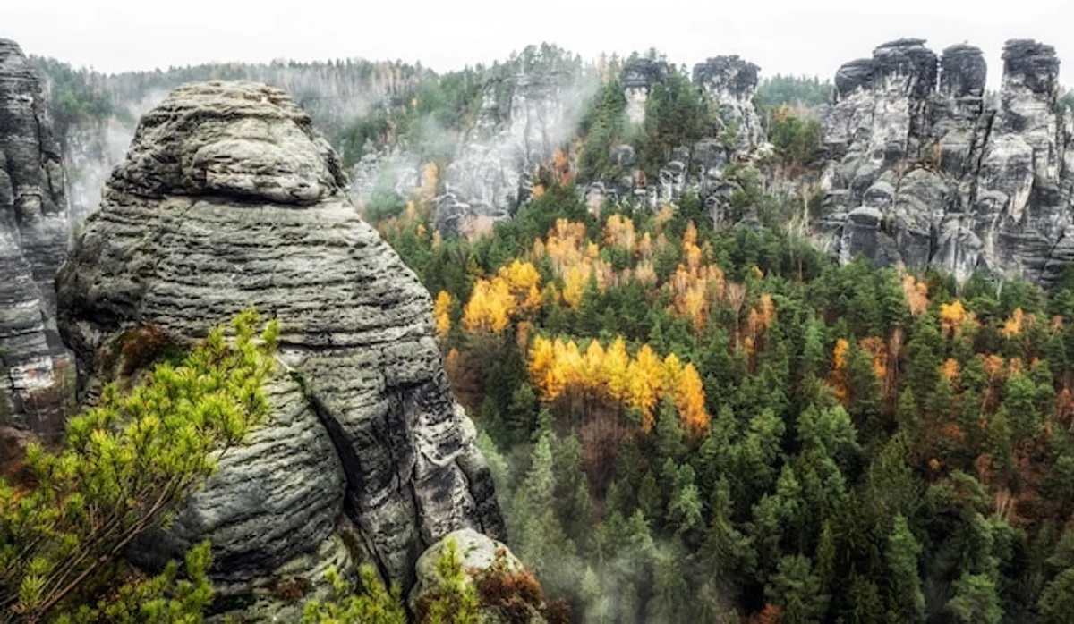 misty autumn mountain trail with hiker in fog czech republic