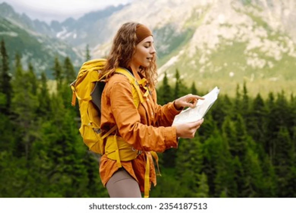 hiker checking map with gloves in cold foggy mountain autumn trail czech republic
