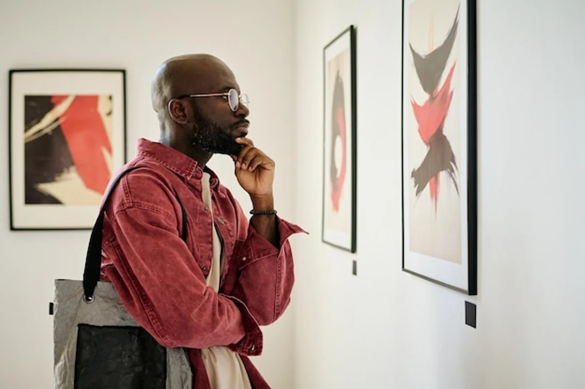 people observing paintings quietly in art museum