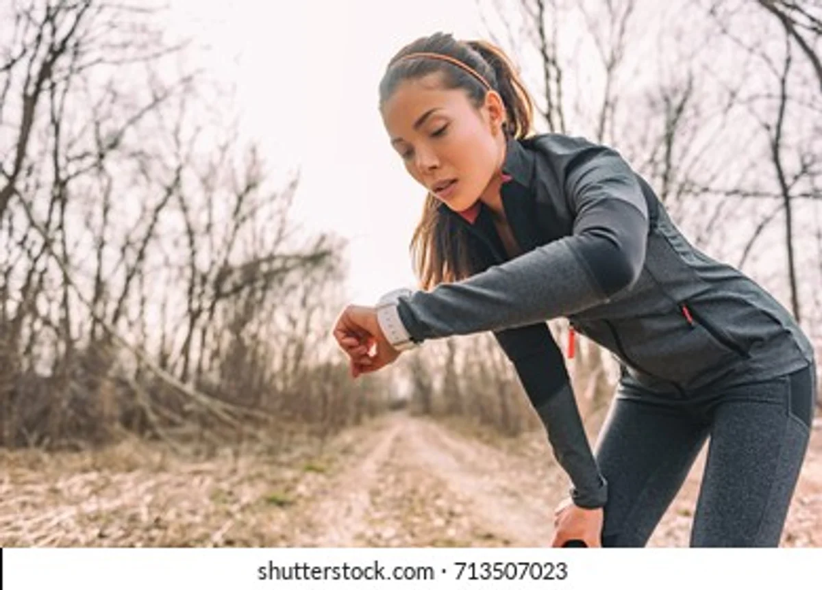 runner using smart watch in autumn park Czech Republic
