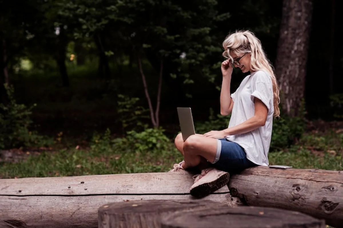 focused young adult at desk with autumn leaves outside window